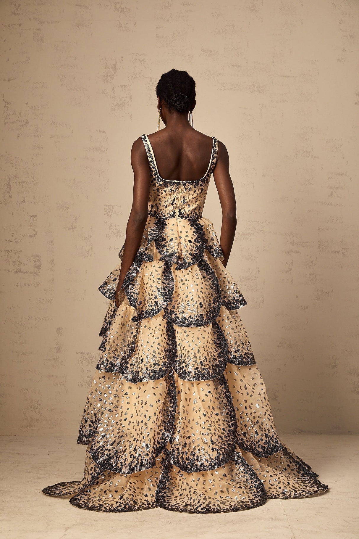 A long tiered maxi dress with sequined petal details and a flowing silhouette