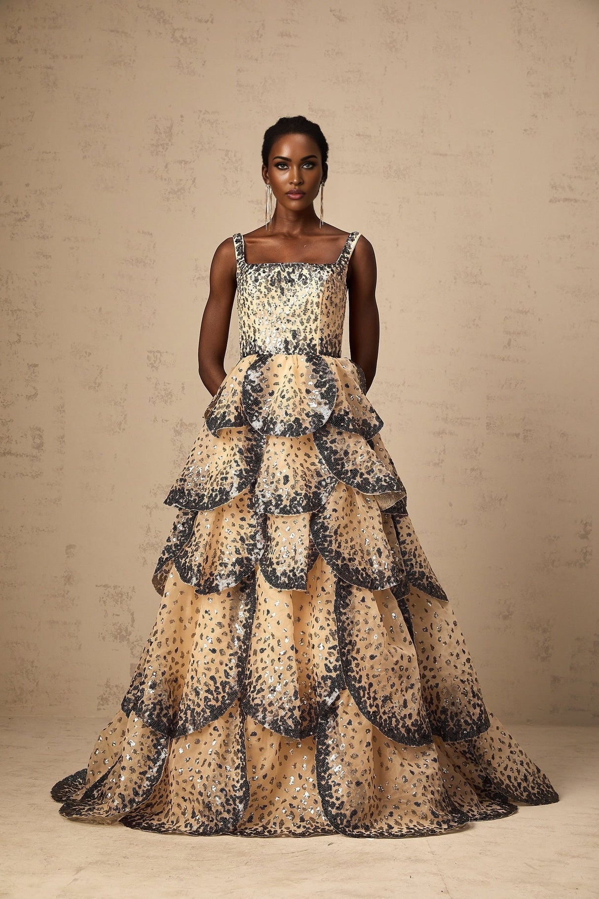 A long tiered maxi dress with shimmering sequined petals cascading down the tiers creating a floral effect