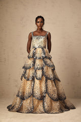 A long tiered maxi dress with shimmering sequined petals cascading down the tiers creating a floral effect