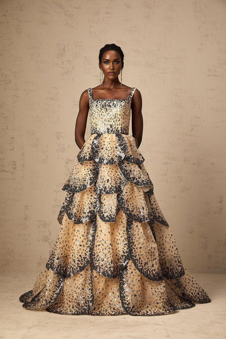 A long tiered maxi dress with shimmering sequined petals cascading down the tiers creating a floral effect