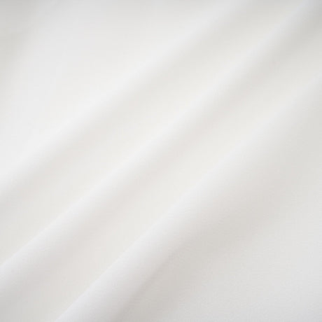 A long white chiffon maxi dress with a halter neck and ruffle details worn by a model against a plain background