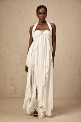 A long white chiffon maxi dress with ruffle details and a halter neckline