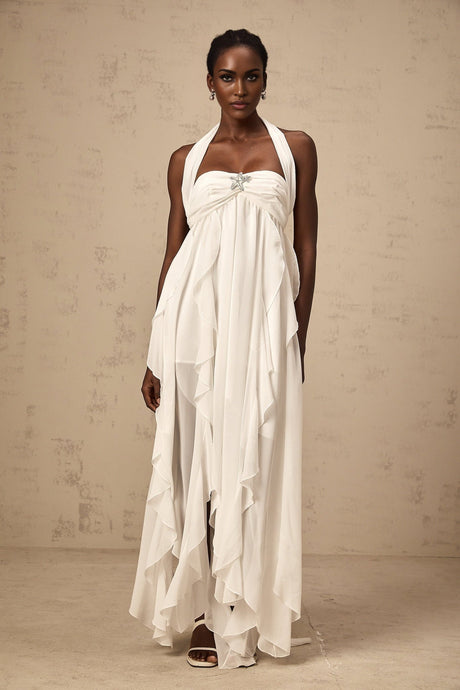 A long white chiffon maxi dress with ruffle details and a halter neckline