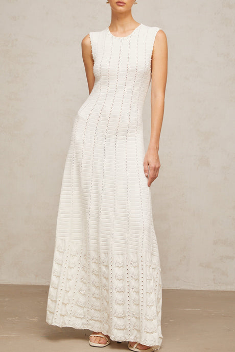 A long white knit maxi dress with pointelle details and faux pearl embellishments