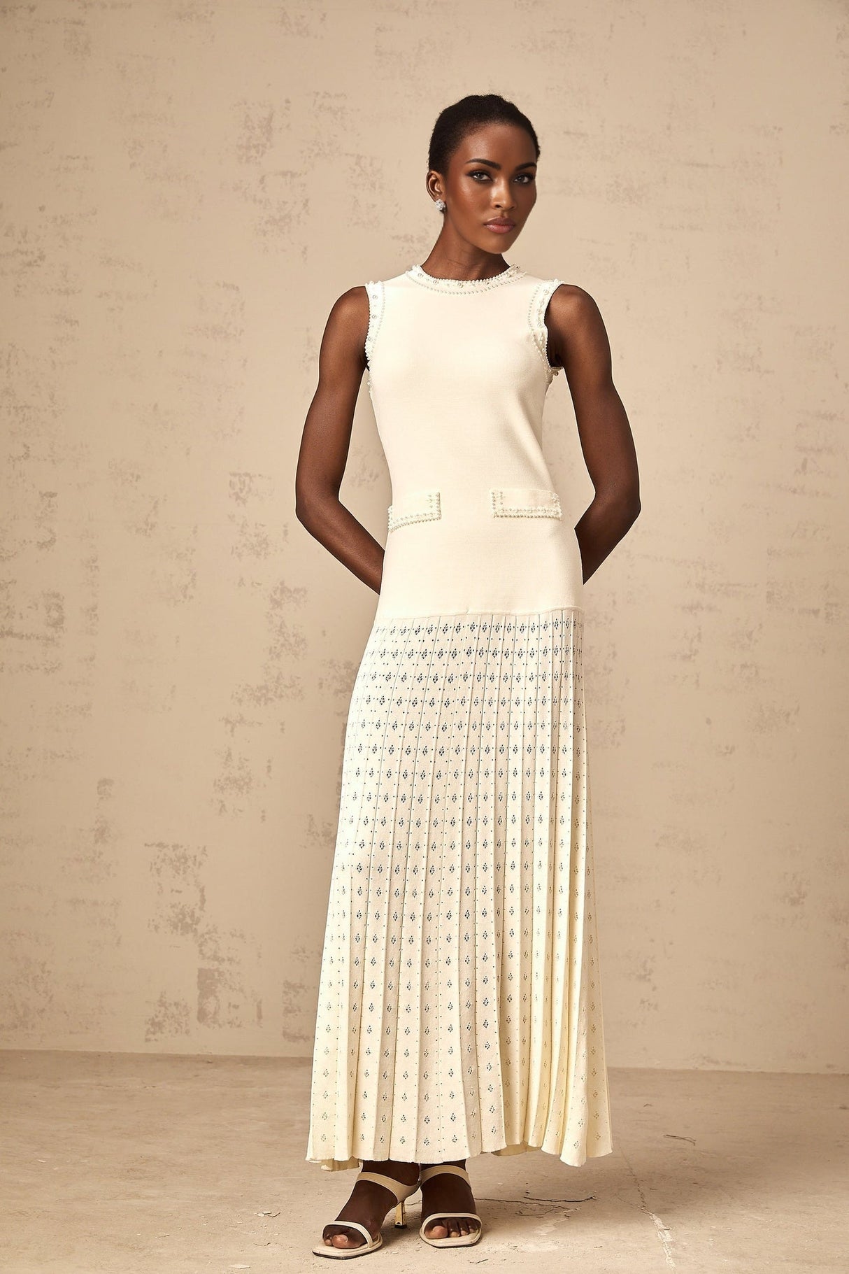 A long white knitted maxi dress with faux pearl embellishments