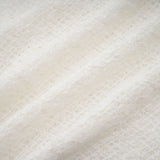 A long white lace maxi dress with a wavy pattern throughout featuring a fitted bodice and flowing skirt
