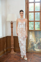 A long white maxi dress with a corset bodice featuring floral applique details and a flowing skirt named Brigitte