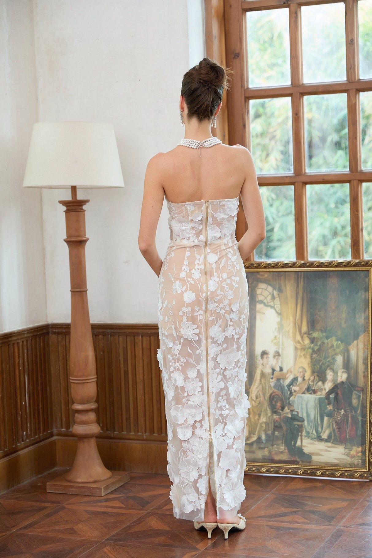 A long white maxi dress with a corset bodice featuring floral applique details named Brigitte