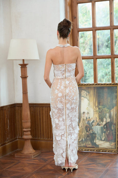 A long white maxi dress with a corset bodice featuring floral applique details named Brigitte