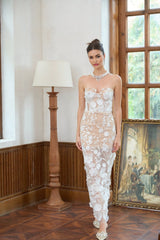 A long white maxi dress with a corsetstyle bodice featuring floral applique details and a flowing skirt