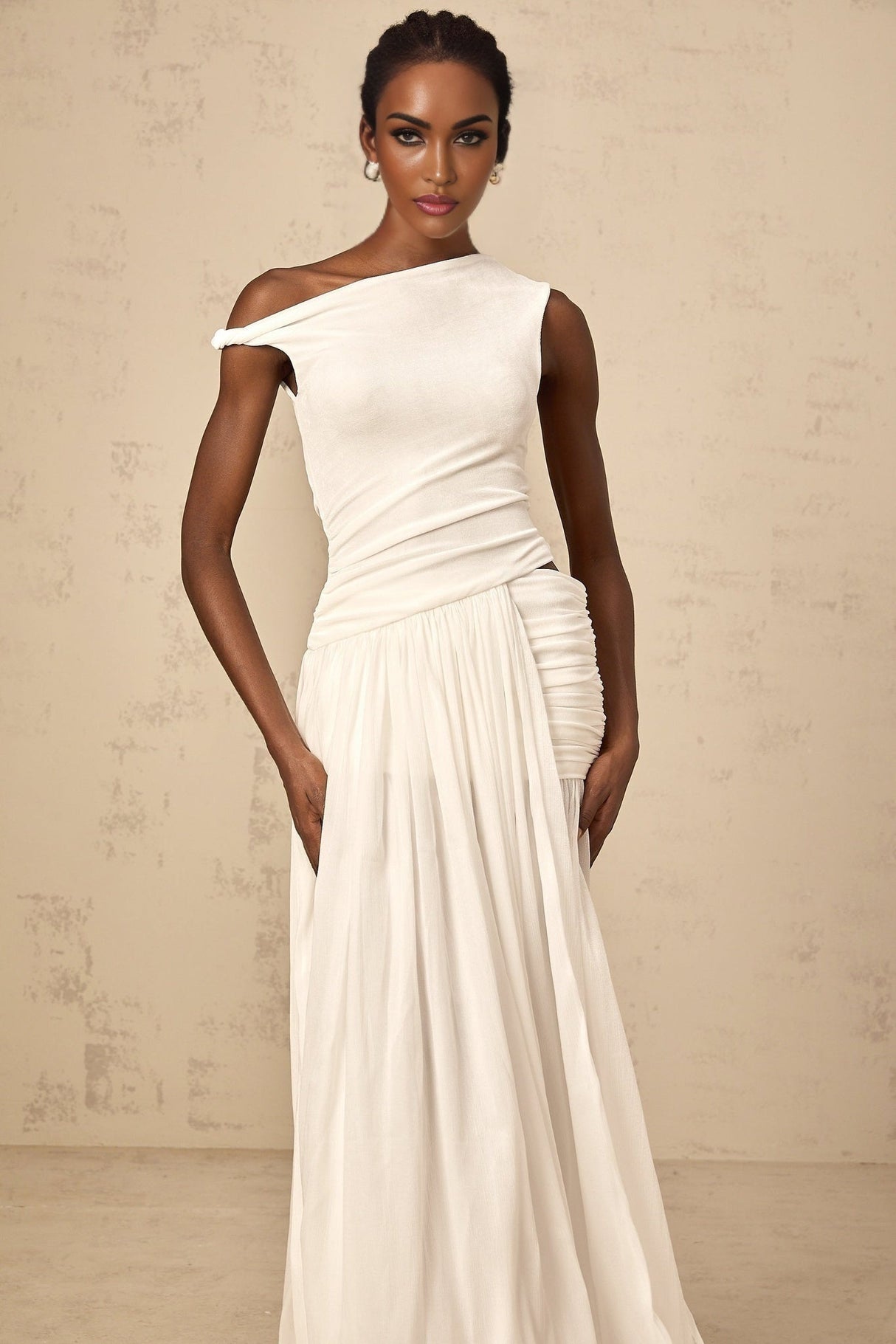 A long white maxi dress with a single shoulder strap and shirred panel detail