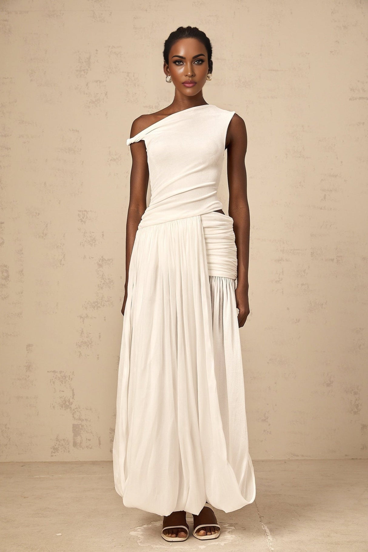 A long white maxi dress with a single shoulder strap and shirred panel detailing on the bodice featuring a fitted waist and flowing skirt