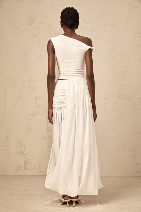 A long white maxi dress with a single shoulder strap and shirred panel detailing on the bodice
