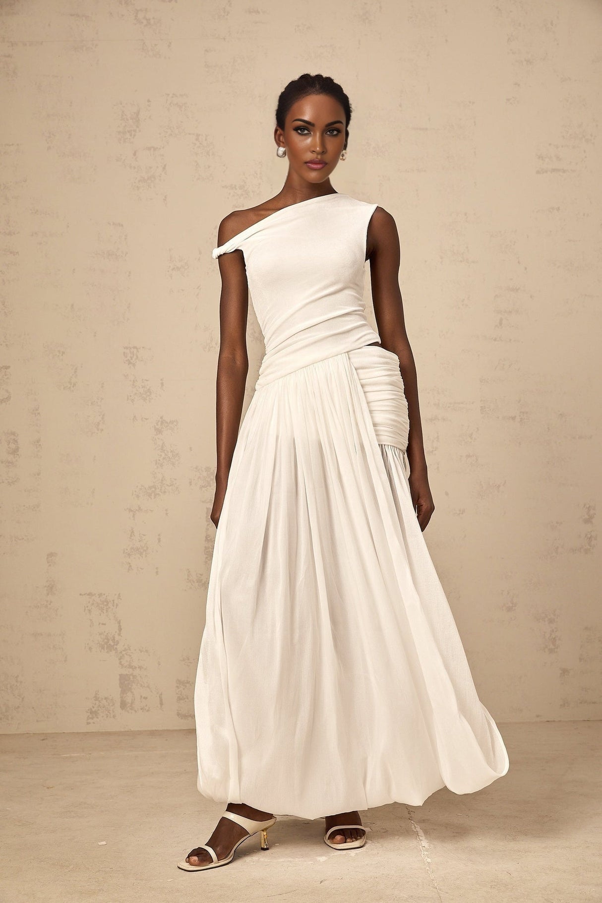 A long white maxi dress with a single shoulder strap and shirred panel detailing