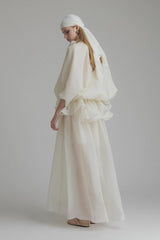 A long white maxi dress with a tie neck and ruffled details