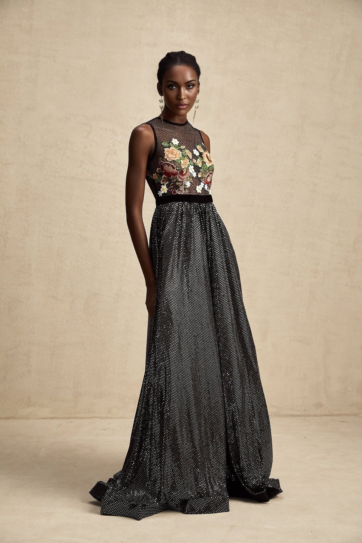 A long white maxi dress with colorful floral embroidery and embellishments covering the fabric