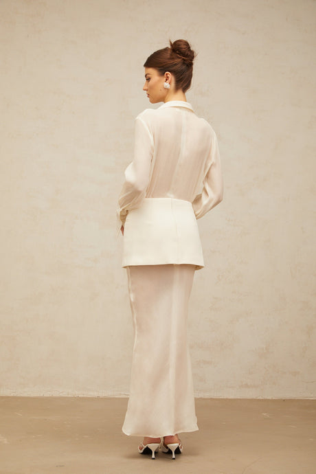 A long white maxi dress with sheer panels and a flowy silhouette