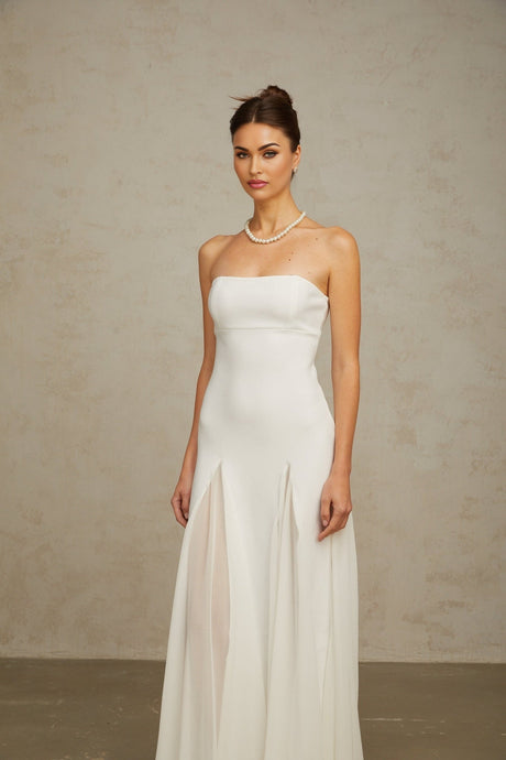 A long white maxi dress with tulle paneling named Nathalie featuring a flowy silhouette and delicate sheer details