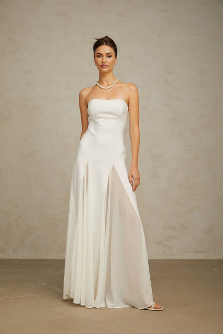 A long white maxi dress with tulle panelling details named Nathalie featuring a flowy silhouette and delicate fabric