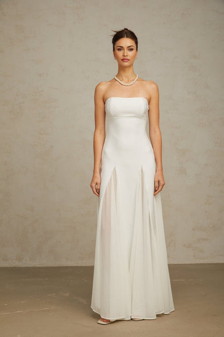 A long white maxi dress with tulle panelling featuring a sleeveless design and flowing skirt