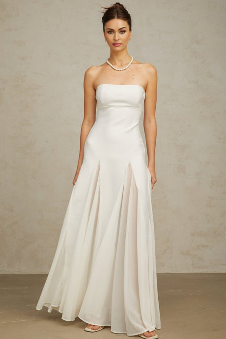 A long white maxi dress with tulle panelling named Nathalie featuring a flowy silhouette and delicate sheer details