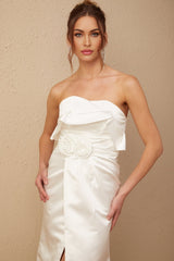 A long white satin dress with floral appliques adorning the fabric elegant maxi length design featuring a delicate floral pattern