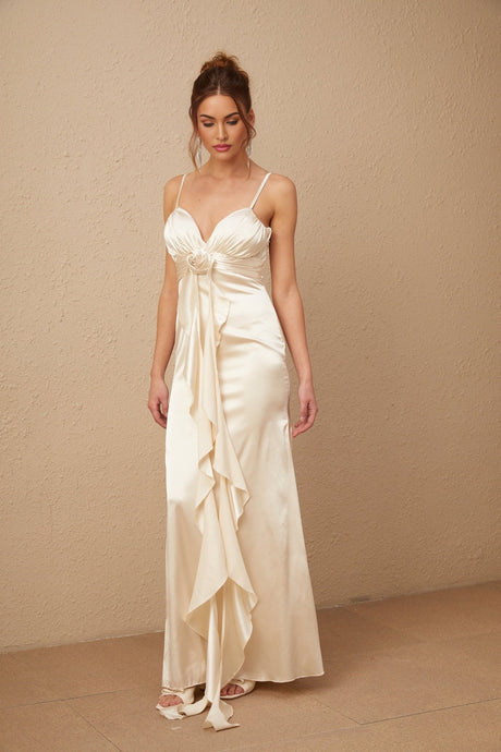 A long white satin maxi dress with a corset bodice featuring colorful floral applique details and a flowing skirt