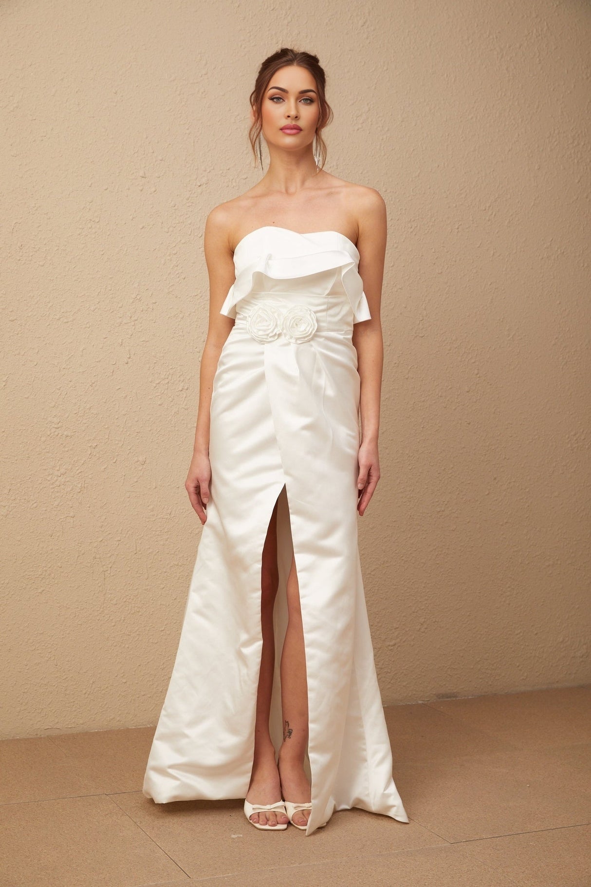 A long white satin maxi dress with delicate floral appliques adorning the fabric
