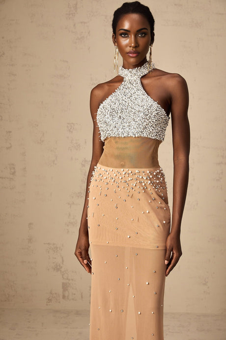 A long white semisheer maxi dress adorned with small faux pearls and featuring a flowy silhouette