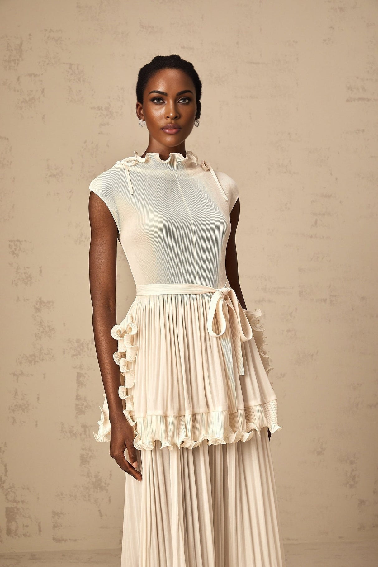 A long white sleeveless maxi dress with ruffles and pleats named Diana