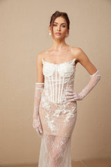 A long white tulle maxi dress with a corset bodice featuring colorful floral embroidery and thin straps