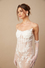 A long white tulle maxi dress with a corset bodice featuring colorful floral embroidery throughout the dress