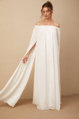 A long white tulle maxi dress with a flowing cape design and elegant draping