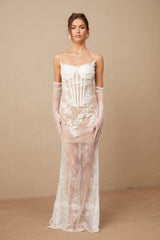 A long white tulle maxi dress with floral embroidery and a corset style bodice featuring delicate straps and a flowing skirt