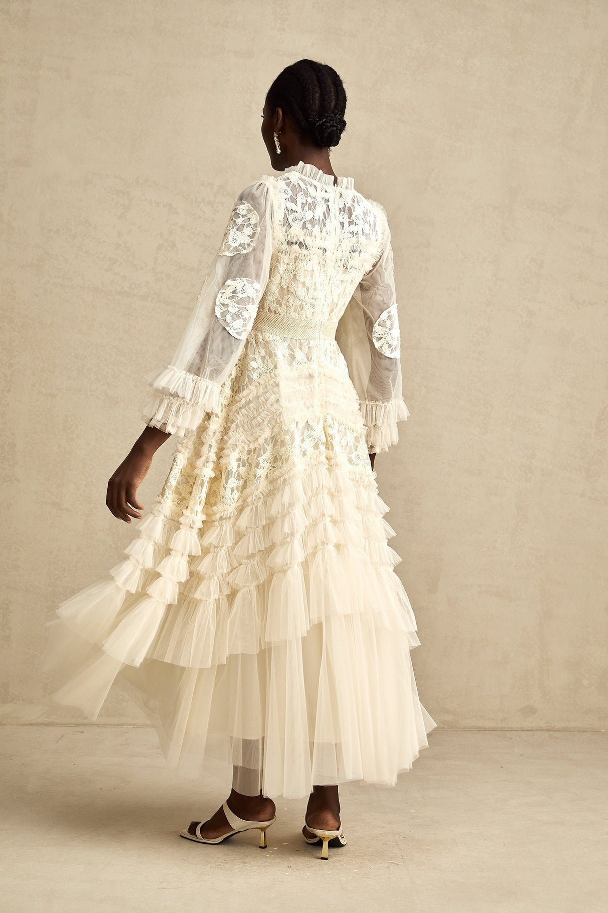 A long white tulle maxi dress with layered skirt featuring delicate floral embroidery in pastel colors named Capucine