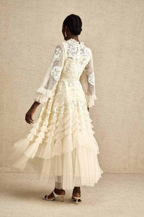 A long white tulle maxi dress with layered skirt featuring delicate floral embroidery in pastel colors named Capucine