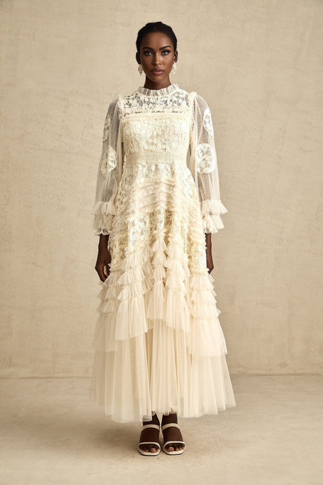 A long white tulle maxi dress with multiple layers featuring delicate floral embroidery in a capucine color pattern