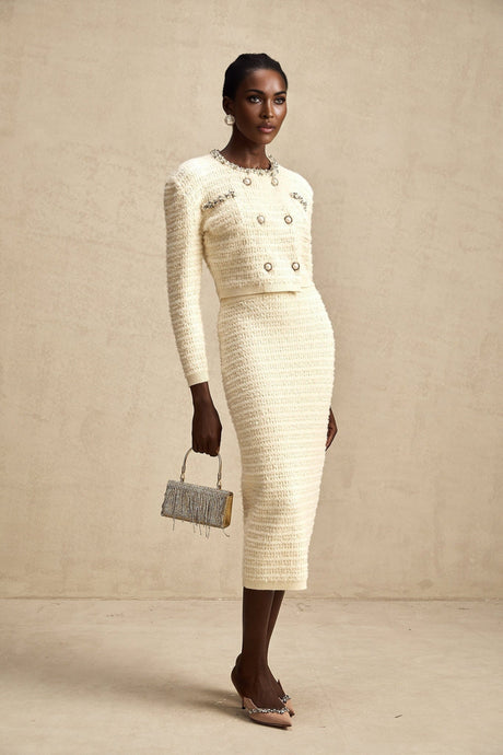 A matching set consisting of a knit cardigan and skirt both embellished with decorative details named Justine The cardigan and skirt are coordinated in style and color creating a cohesive outfit