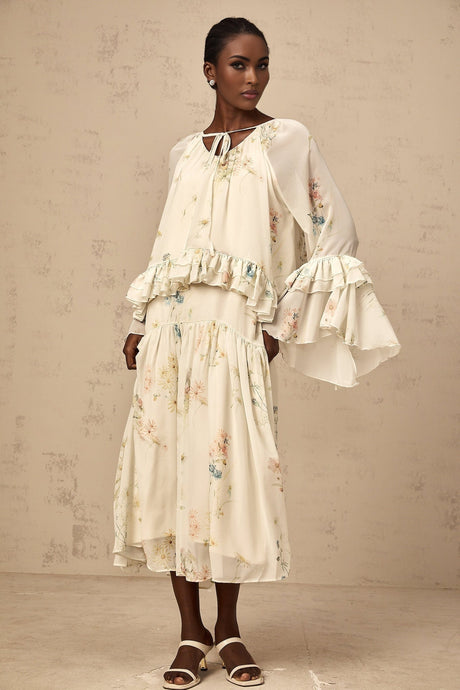 A matching set featuring a floral print blouse with ruffles and a coordinating dress in the same pattern and colors
