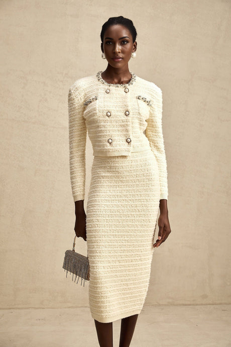 A matching set featuring a knit cardigan and skirt with embellishments called Justine The cardigan and skirt are coordinated in style and color creating a cohesive outfit
