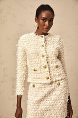 A matching set featuring a white furry knit cardigan and skirt on a model against a plain background