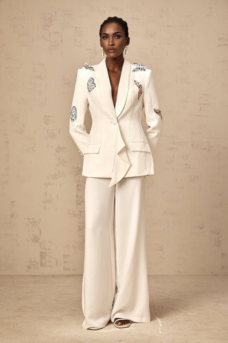 A matching white blazer and trouser set with butterfly appliques embellished throughout the garment