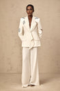 A matching white blazer and trouser set with butterfly appliques embellished throughout the garment