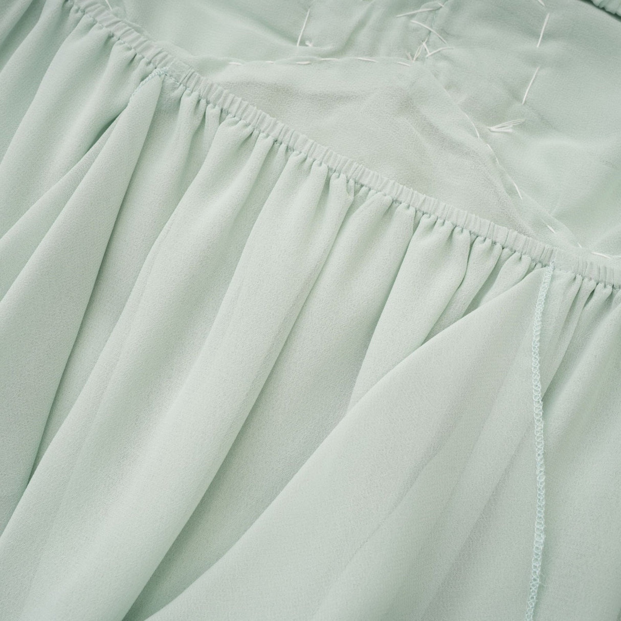 A midi dress with ruffles and embellishments called Salilah featuring a feminine silhouette and decorative details