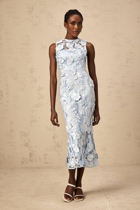A midi length dress in blue fabric featuring colorful floral applique details