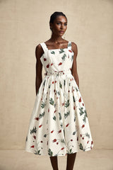A midilength dress with a floral print pattern on white poplin fabric featuring a fitted bodice and flowy skirt