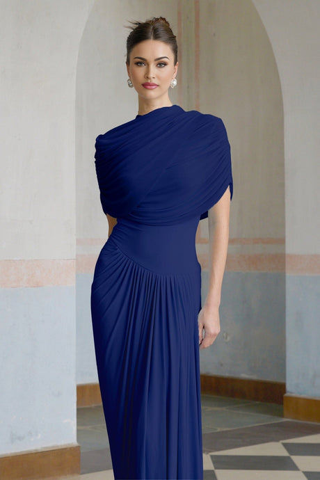 A navy blue maxi dress with an asymmetric hemline and pleated details worn by a model standing against a plain background