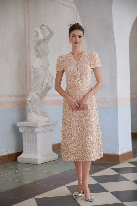 A neutral colored midi dress with crochet detailing and faux flower embellishments modeled on a female figure