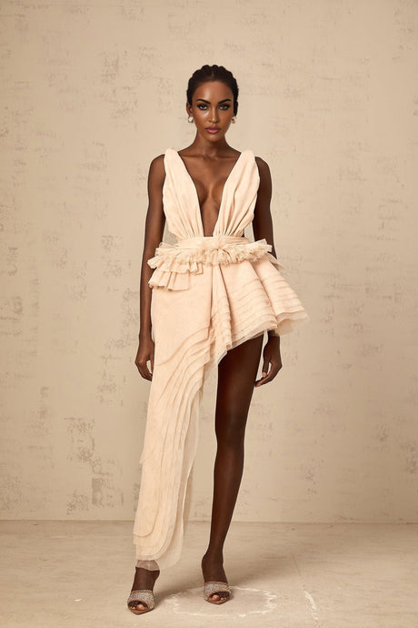 A neutral colored mini dress with an asymmetric hemline featuring a ribbon design detail
