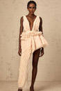 A neutral colored mini dress with an asymmetric hemline featuring a ribbon design pattern across the fabric